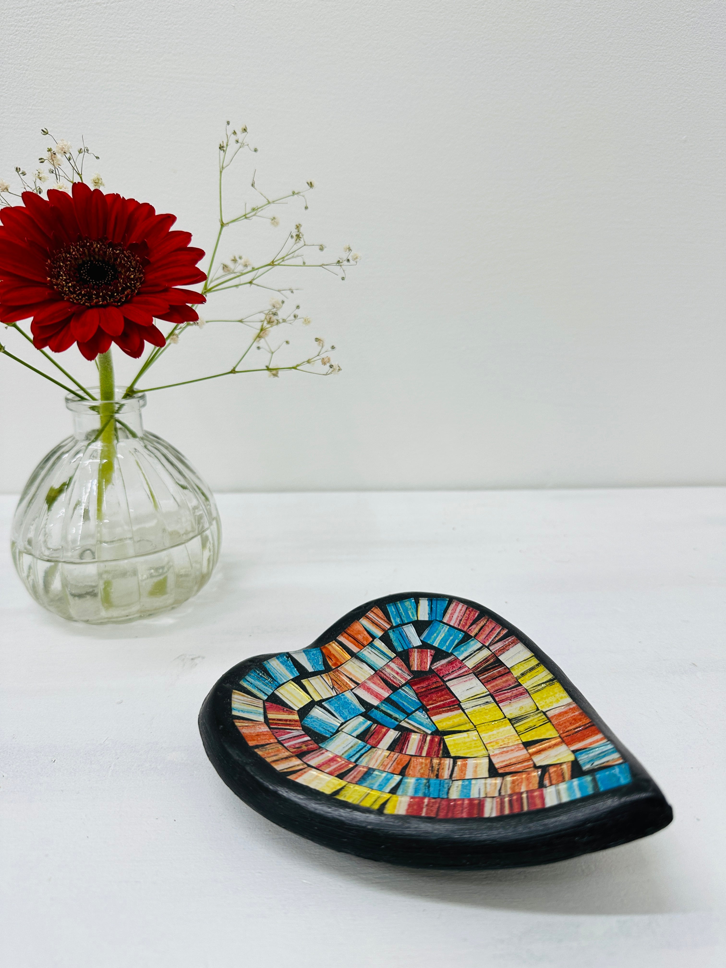 display view of mosaic heart bowl with a vase of flowers 