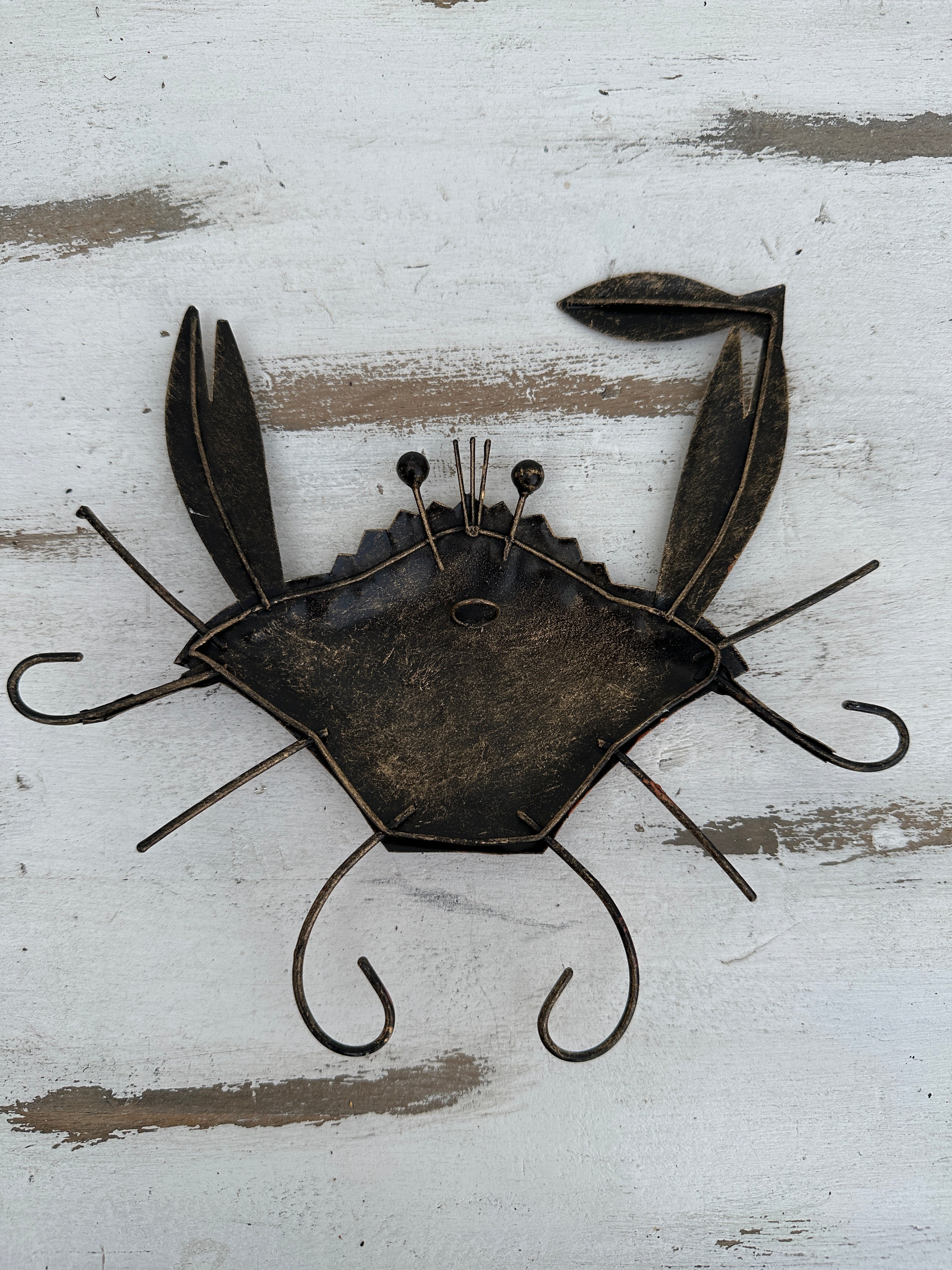 aerial back view of metal copper crab with hook attached to the back