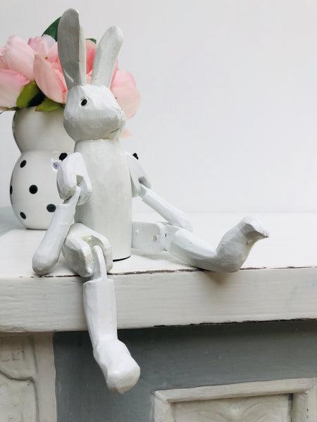 front view of wooden bunny sat on a white surface 