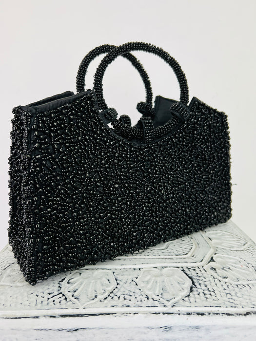 side front view of beaded handbag in black