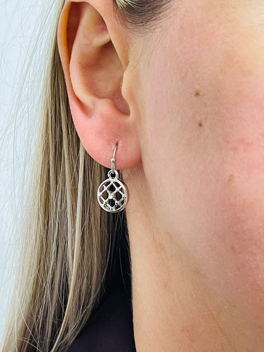 Silver-colored earrings with a simple cross diamond pattern and tiny crystal detail, displayed on a model.
