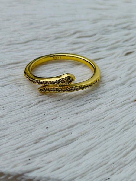 Delicate silver sleek snake ring with fine pave-style detailing and adjustable open band, displayed on a white fabric background.