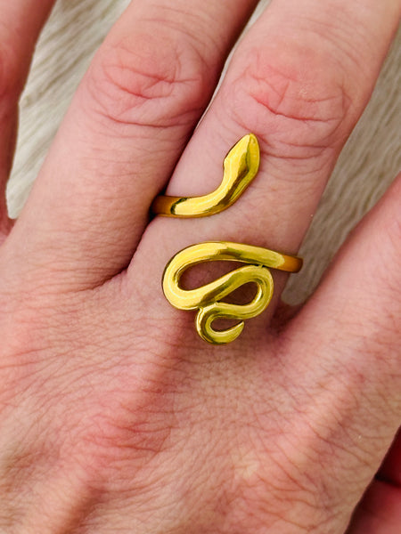 Gold-tone adjustable snake ring with sleek wrap-around design, displayed on a model.