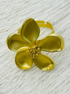 Adjustable statement ring with matte gold-tone five-petal flower and textured centre, displayed on a white background.