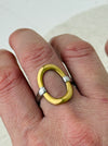Two-tone open band ring with silver adjustable band and gold circular accent, displayed on a model.