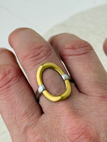Two-tone open band ring with silver adjustable band and gold circular accent, displayed on a model.