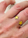 Twin star adjustable ring with two gold-tone stars on a silver-tone open band, displayed on a model.