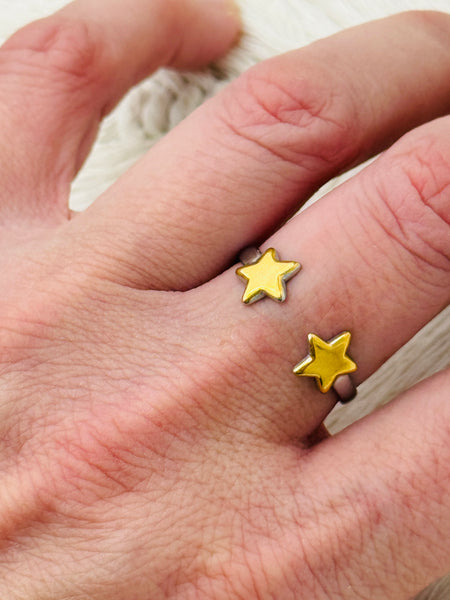 Twin star adjustable ring with two gold-tone stars on a silver-tone open band, displayed on a model.