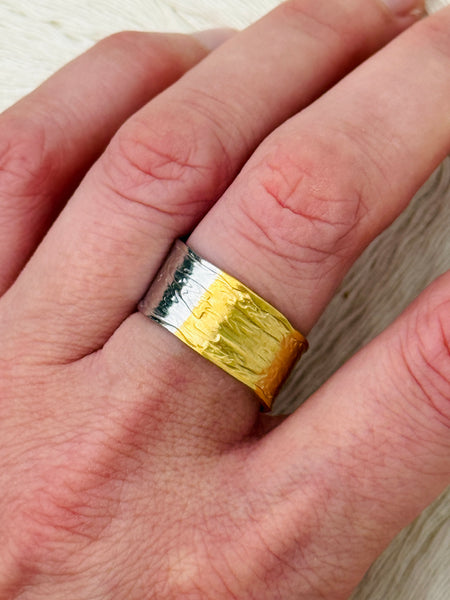 Bi-tone open band ring with textured silver and gold finish on a  model.