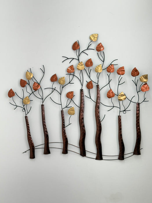 Decorative wall art with metal branches and leaves on a white background