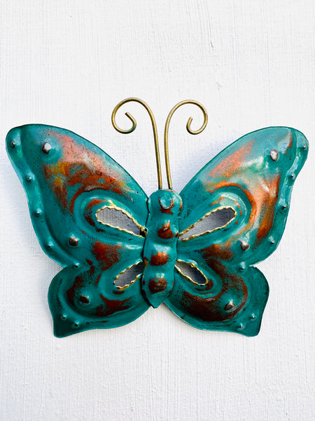 front view metal butterfly in blue on white wall