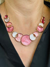Aurea enamel necklace with rose-gold circular design in a celestial-inspired style.