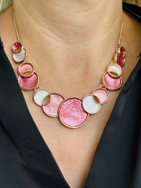 Aurea enamel necklace with rose-gold circular design in a celestial-inspired style.