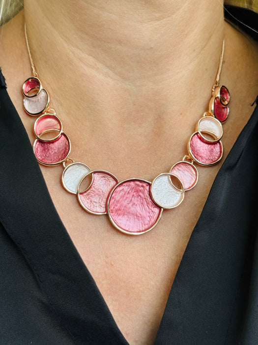 Aurea enamel necklace with rose-gold circular design in a celestial-inspired style.