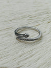 Delicate silver sleek snake ring with fine pave-style detailing and adjustable open band, displayed on a white fabric background.