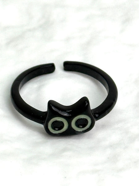Black cat-shaped ring with glowing eyes on a white background