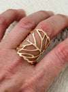 Gold-tone adjustable openwork ring with delicate leaf vein design, displayed on a model.