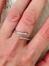 Delicate silver sleek snake ring with fine pave-style detailing and adjustable open band, displayed on a model.