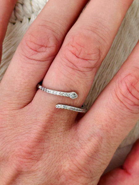 Delicate silver sleek snake ring with fine pave-style detailing and adjustable open band, displayed on a model.