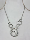 Silver necklace with interlocking rings on a mannequin.