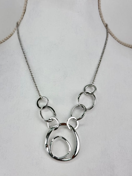 Silver necklace with interlocking rings on a mannequin.