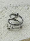 Silver serpent ring with coiled textured snake design and adjustable open band, displayed on a white fabric background.