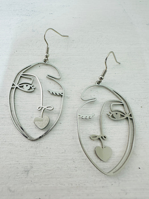 front of abstract portrait dangle earrings
