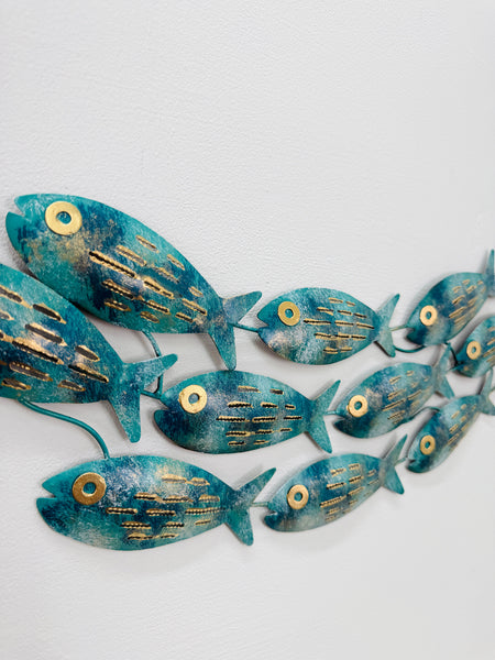 Close-up of hand-painted aqua metal fish showing mottled finish and gold accents