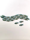 Display view of 18-piece aqua metal fish shoal wall art with 3 single on a white surface