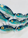 Close-up of hand-painted aqua striped metal fish with gold detailing