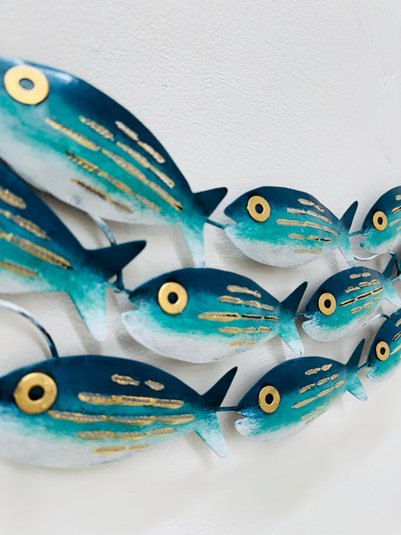 Close-up of hand-painted aqua striped metal fish with gold detailing