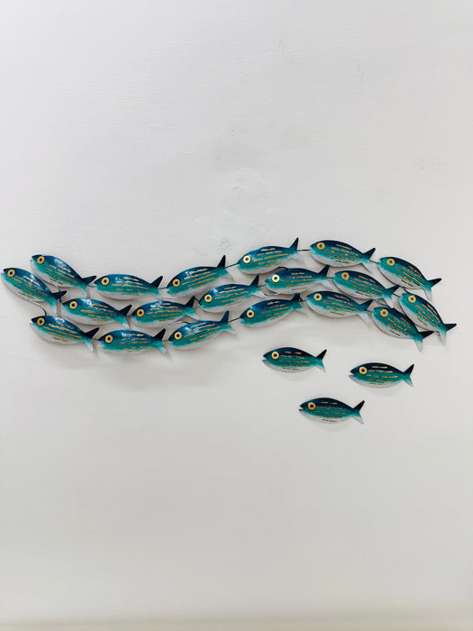 Display view of 18-piece aqua striped metal fish shoal wall art with 3 single fish on a white surface