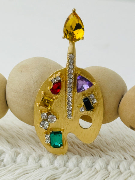 gold-tone artist palette brooch decorated with colourful crystals