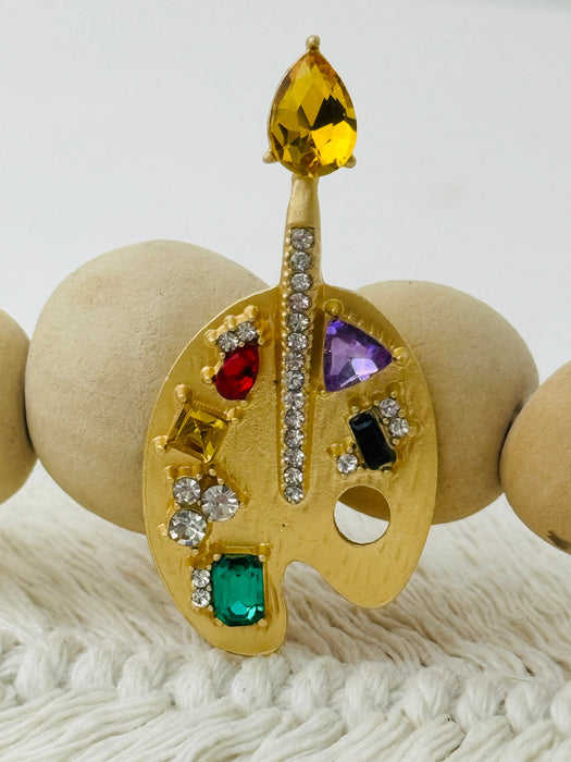 gold-tone artist palette brooch decorated with colourful crystals