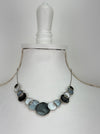 Aurea necklace with geometric enamel circles on a display mannequin.