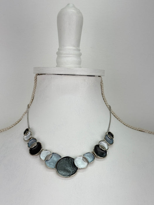 Aurea necklace with geometric enamel circles on a display mannequin.