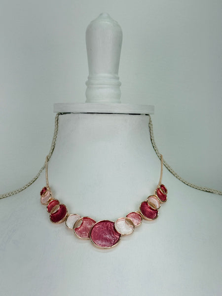 Aurea enamel necklace with rose-gold circular design in a celestial-inspired style.