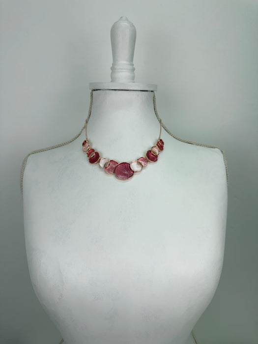 Aurea enamel necklace with rose-gold circular design in a celestial-inspired style.