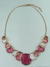 Aurea enamel necklace with rose-gold circular design in a celestial-inspired style.