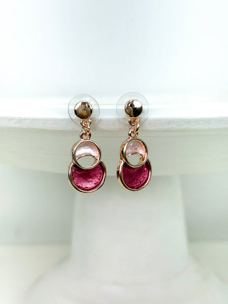 Rose-gold drop earrings with circular design.