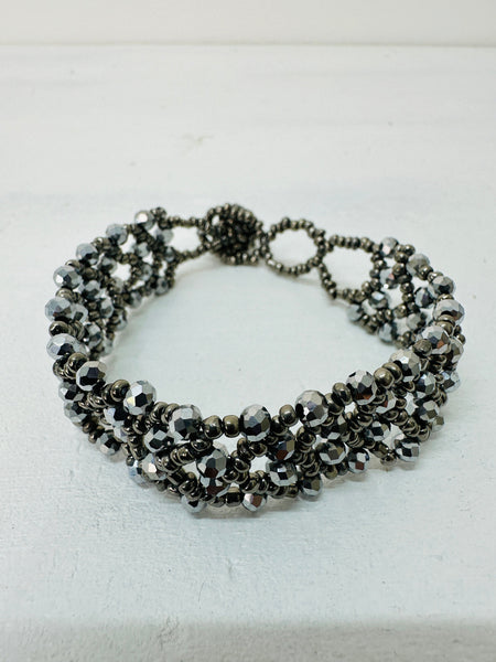 A silver bracelet with a combination of seed beads and gemstones, featuring an easy fastening button and loop.