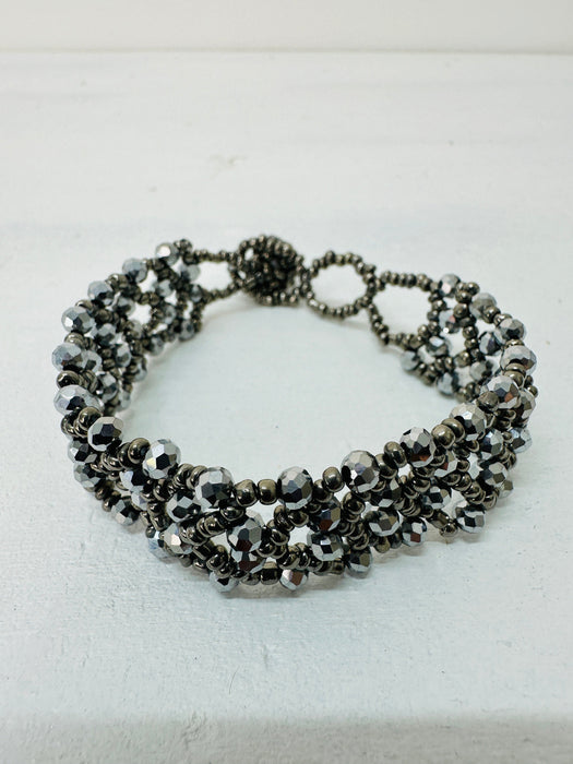 A silver bracelet with a combination of seed beads and gemstones, featuring an easy fastening button and loop.