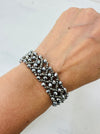 Silver beaded bracelet on a wrist against a white background