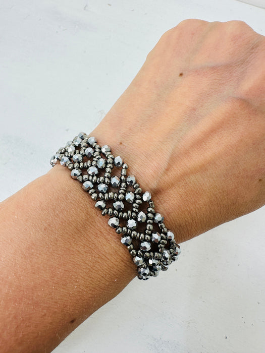 Silver beaded bracelet on a wrist against a white background
