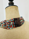Back view of a multicoloured beaded necklace with a dark brown wooden clasp.
