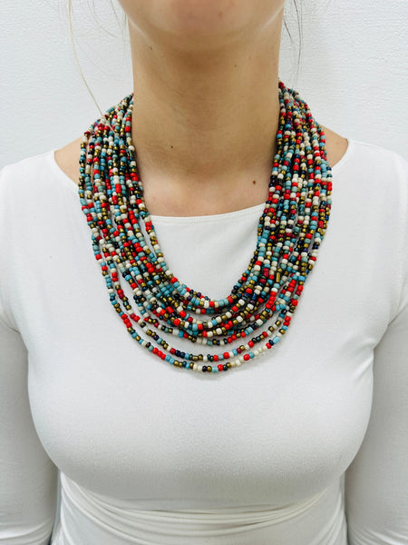 Bead statement waterfall style necklace with multicoloured seed beads and hand carved wood clasp., displayed on a model.
