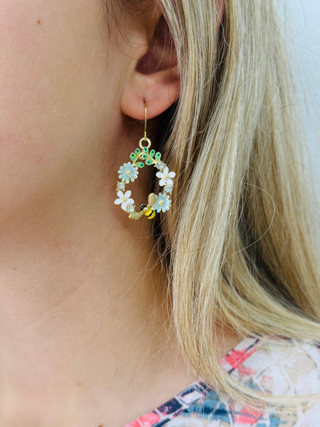Bee and daisy, floral dangle earrings with enamel flowers, sparkling rhinestones, and gold-tone bee detail, displayed on a model.