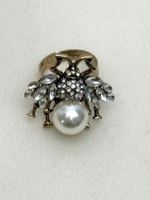 Decorative bee statement ring with pearl and crystal accents on a white background