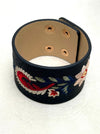 black faux leather cuff with floral embroidery on a white background