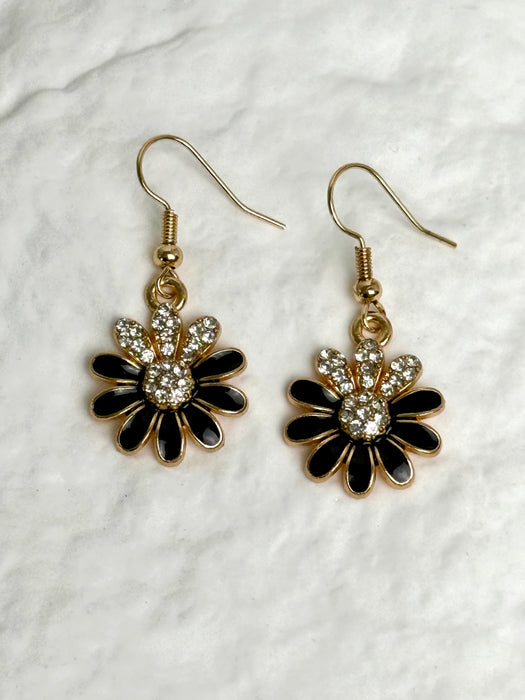 Pair of floral earrings with black and gold details on a white background